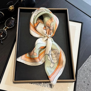 Floral silk scarf in green and pink with a pearl buckle, styled with luxury accessories