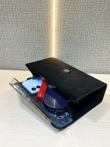 Detail of black velvet evening clutch showing interior storage for lipstick and phone