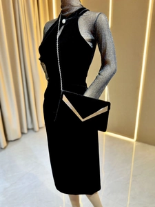 Detail of luxury black velvet envelope clutch bag with silver V-shaped metal trim and chain