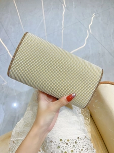 Macro shot of faux pearl evening clutch with gold glitter trim and hard rectangular case