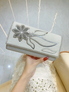 Detailed view of luxury pearl evening clutch bag with crystal flower and silver accents