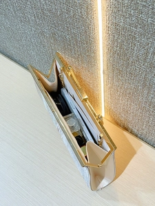 Detail view of large evening clutch interior showing space for phone and makeup