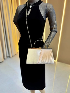 Detail of champagne gold evening clutch with pleated texture and round metal handle