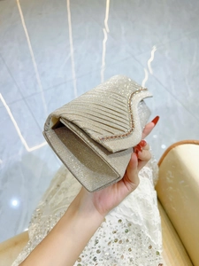 Champagne gold luxury clutch bag with wavy pleated design and S-curve sparkling rhinestones