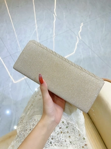 Detail of champagne gold evening clutch bag with sequins and diagonal flap edge texture