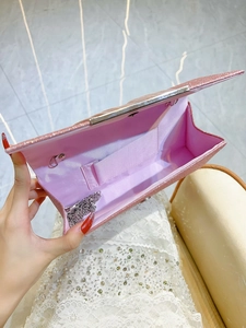 Pink sequin evening clutch bag with silver chain strap shown in an open top view