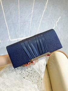 Detail of navy blue sequined evening clutch bag with pleated texture and silver metal clasp