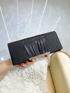 Macro shot of black sequin clutch bag with pleated detail and silver metal bar