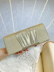 Detailed texture of sparkling gold sequin evening clutch with layered pleated design