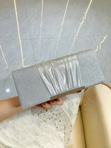 Detail of silver sequin evening clutch bag with pleated satin texture and metal clasp