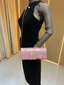 Detail of pink sequin clutch bag featuring pleated flap and elegant gold chain strap