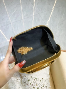 Golden luxury evening clutch bag with chain strap shown from an open perspective