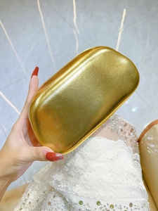 Detailed view of luxury gold evening clutch with elegant brushed metal texture finish