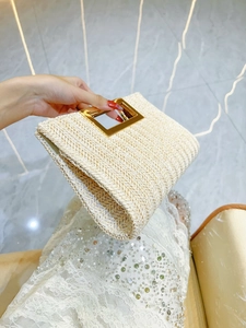 Beige woven straw handbag with a stylish gold metal handle for elegant summer travel