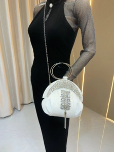 Détail du sac de soirée en satin blanc avec strass brillants et pompons métalliques