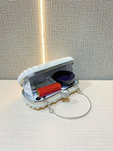Detailed interior view of pearl evening clutch bag showing lipstick and perfume storage
