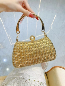 Detail of golden evening clutch with 3D rose sequins, pearl clasp, and metal ring handle