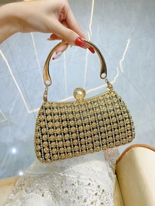 Detail of gold evening clutch featuring rose relief, sparkling diamonds and pearl clasp