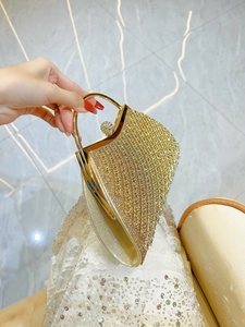 Elegant gold evening clutch bag with sparkling rhinestones and round metal handle