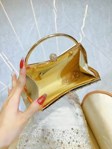 Elegant champagne gold evening clutch bag with metal handle and glitter details