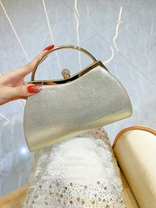Detail of champagne sequin evening clutch with golden metal handle and rhinestone clasp