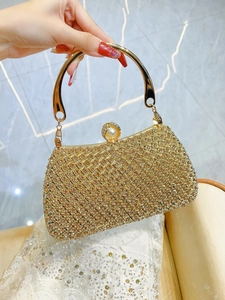 Detailed close-up of champagne rhinestones and large pearl clasp on luxury evening clutch
