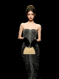 Detail of a semi-circular gold evening bag with textured grid patterns and velvet gloves