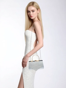 Detail of silver evening clutch with sparkling rhinestones and golden ring handle