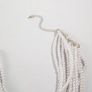 Detail of multi-layer pearl necklace with silver-tone lobster clasp and extension chain