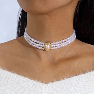 Detail of a vintage 3-layer pearl choker necklace with a gold oval centerpiece and large pearl