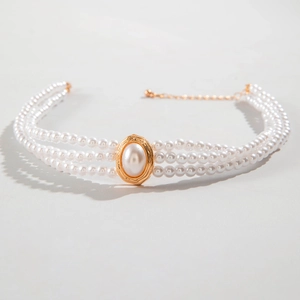 Detailed view of triple-layer pearl necklace with golden oval centerpiece and lobster clasp