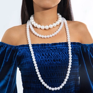 Close-up of three-layer gradient faux pearl necklace set on an elegant model