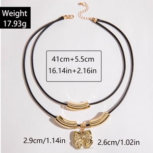 Detalle de collar de doble capa de cordón negro con colgante de lazo dorado y dimensiones