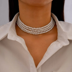 Detail of four-layer faux pearl choker necklace worn with a white professional shirt