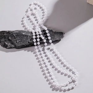 Detailed view of elegant white pearls layered on natural black stone textures