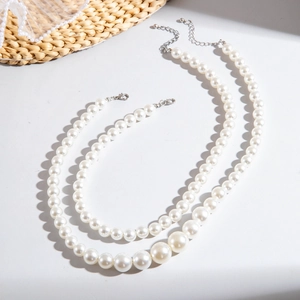 Detail of layered white faux pearl necklaces with adjustable silver lobster clasp