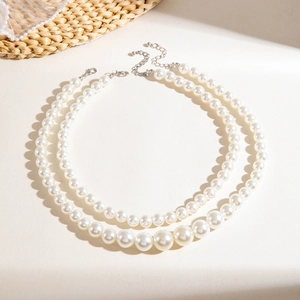 Detail of layered imitation pearl necklaces with lobster clasp and adjustable silver chain