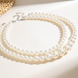Detail of double-layer faux pearl necklace with silver lobster clasp and extension chain