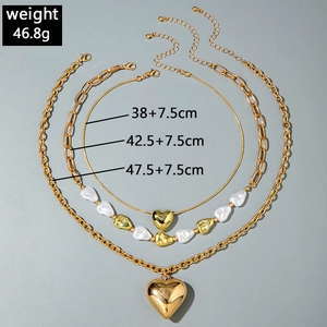 Vista detallada de collar multicapa dorado con colgantes de corazón y medidas reales