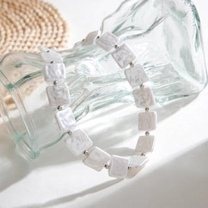 Detail view of retro geometric beaded necklace featuring pearlescent square resin beads