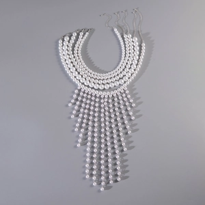Macro detail of multi-layer white pearl necklace with layered fringe tassel design