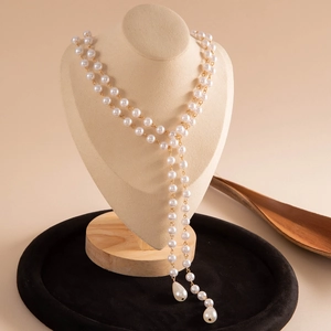 Detail of vintage Y-shaped layered necklace with white pearls and gold metal chain