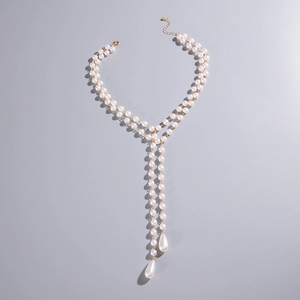 Detailed view of gold Y-shaped double-layer necklace with white faux pearls and drops