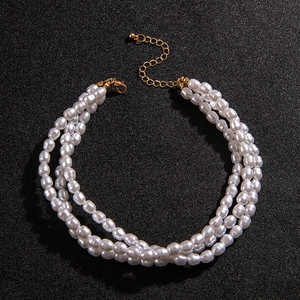 Macro view of multi-layer baroque pearl necklace featuring adjustable golden lobster clasp