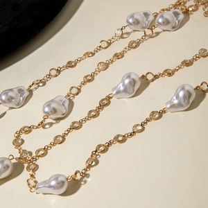 Macro shot of baroque pearls and crystal-encrusted gold chains for layered necklace