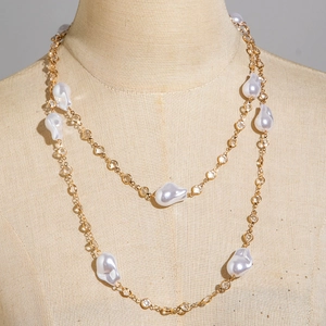 Detail of double-layer gold necklace with baroque pearls and sparkling zircon accents