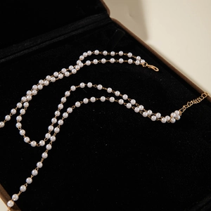 Detail of double-layer pearl necklace with golden clasp and adjustable extension chain