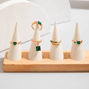 Set dettagliato di cinque anelli dorati con pietre preziose verde smeraldo su supporti