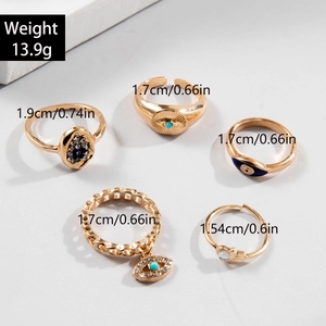Vue détaillée du lot de bagues dorées vintage avec perles bleues et breloques main de fatma