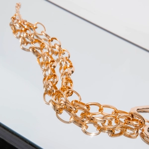 Macro detail of layered gold chunky aluminum chains with glossy metallic interlocking links